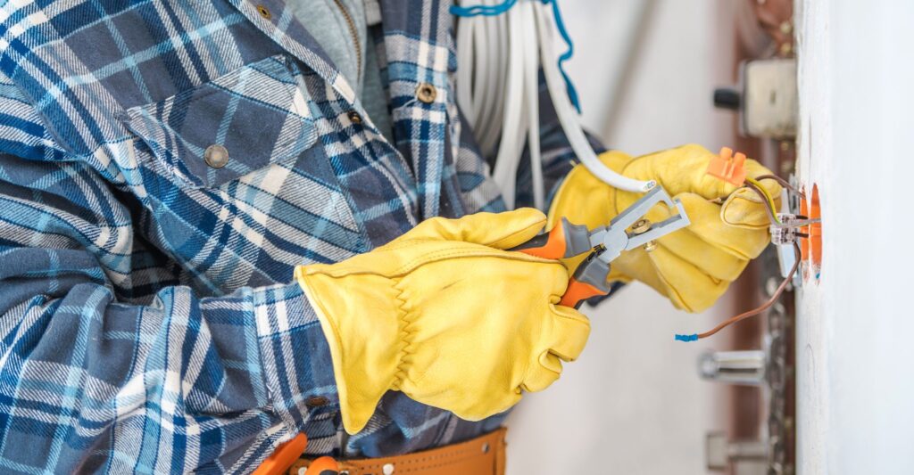 electrician wearing yellow glove clipping a wire